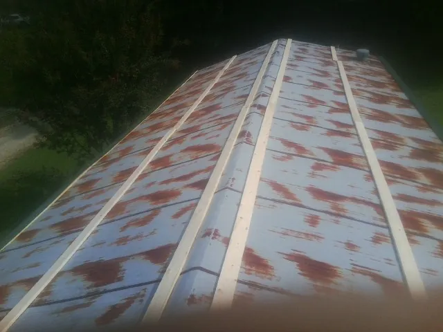 Rusted metal roof panels with new wood purlins before replacement — Storm Damage Roof Repair in Kensal by Roofing Brothers